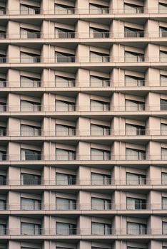 Close-up of a modern apartment building facade with repeating balconies in warm light.