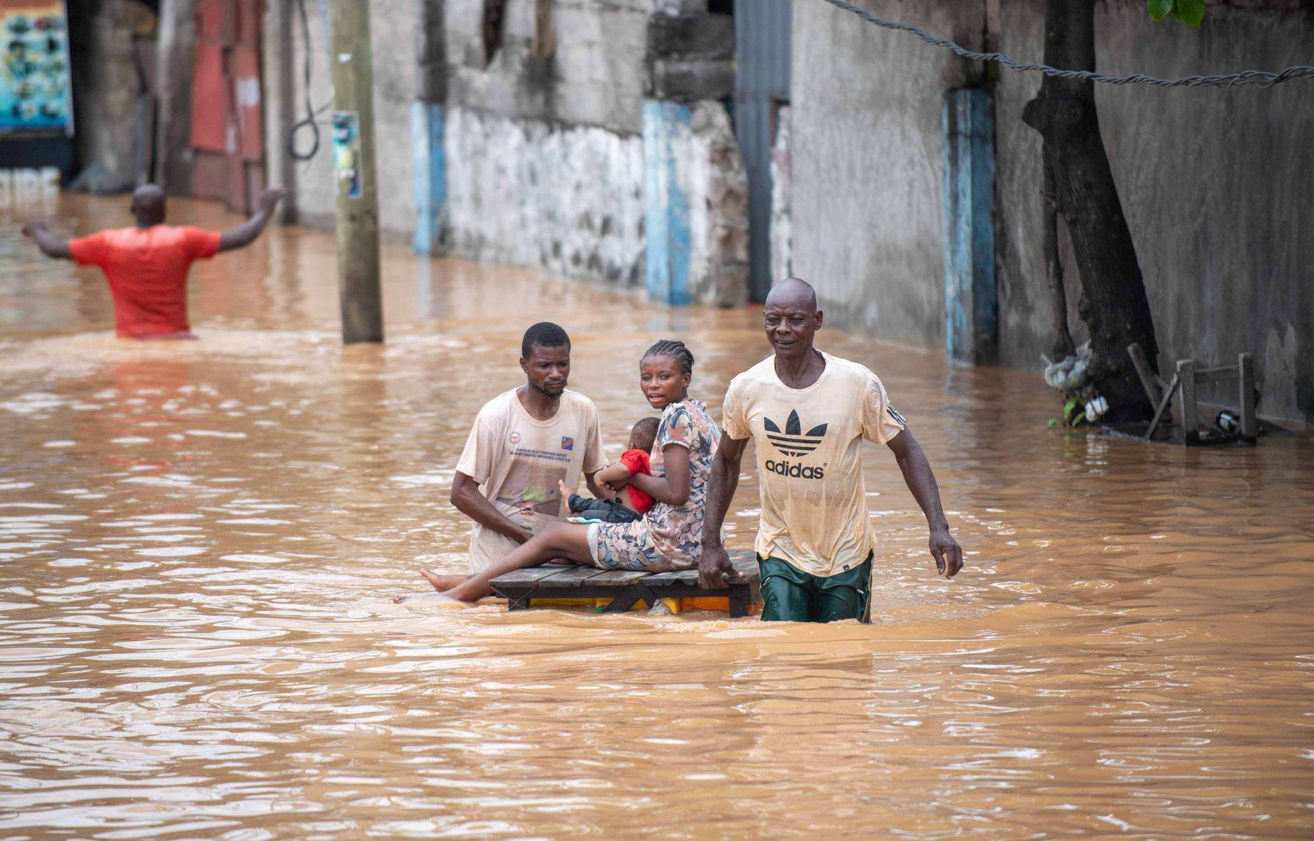 People navigating a flooded street, showcasing resilience amidst natural disaster in Africa.