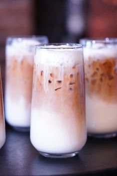 Close-up of delicious iced coffee with layered milk served in clear glasses, perfect for a summer refreshment.