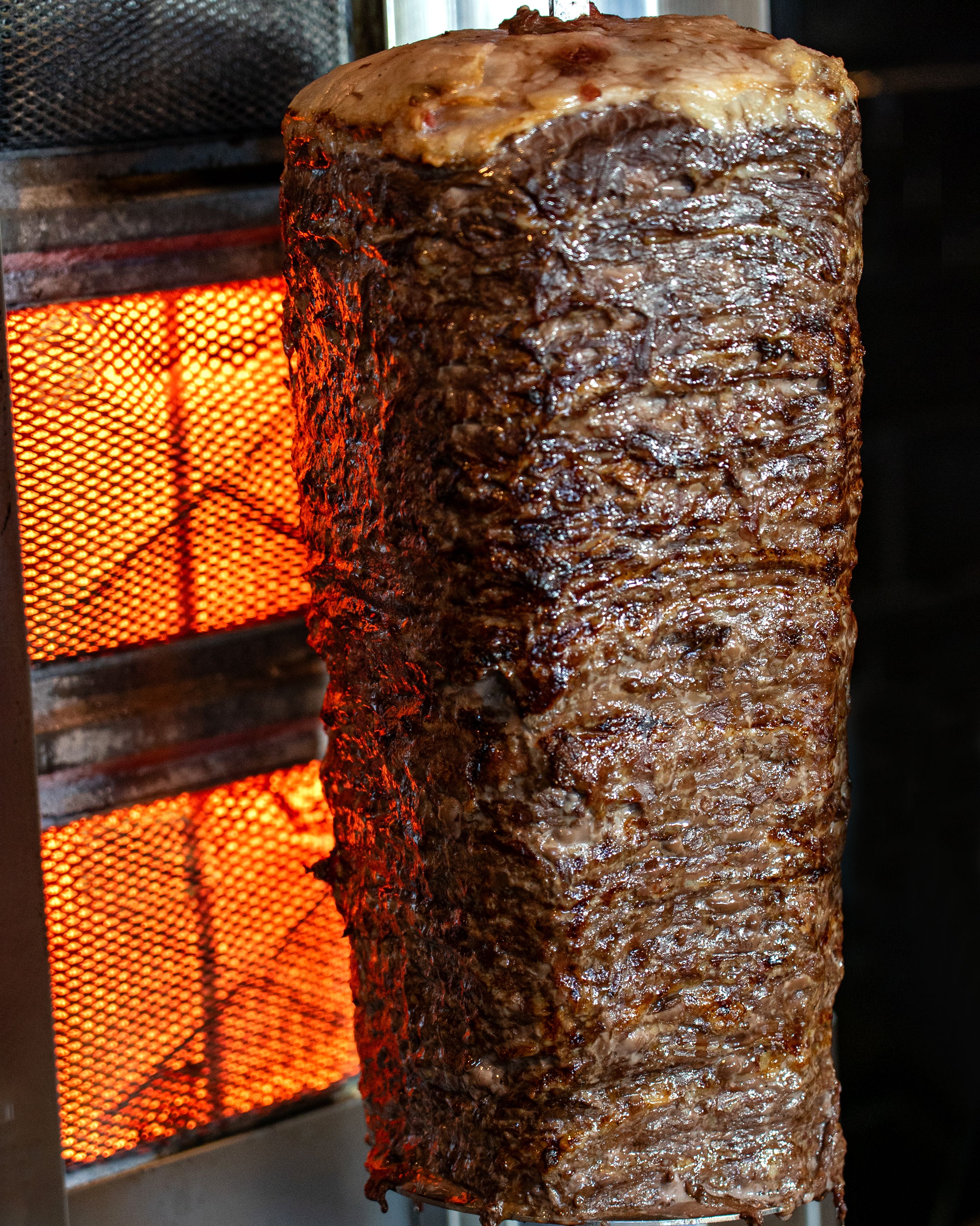 Juicy Beef Shawarma Rotating on Vertical Spit · Free Stock Photo