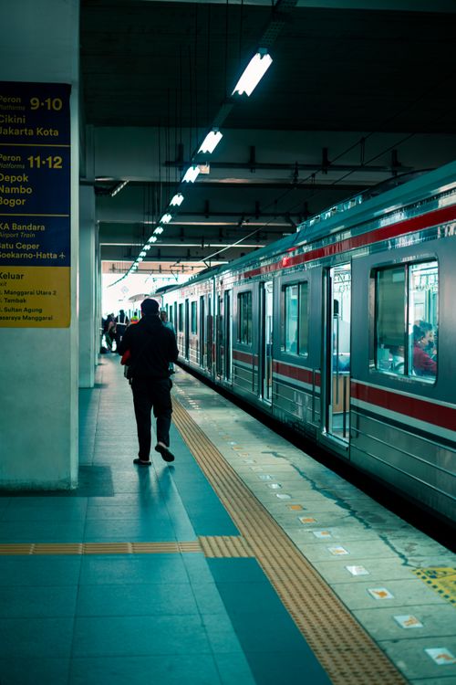 Free Commuter walking along Jakarta train station platform during morning rush. Stock Photo