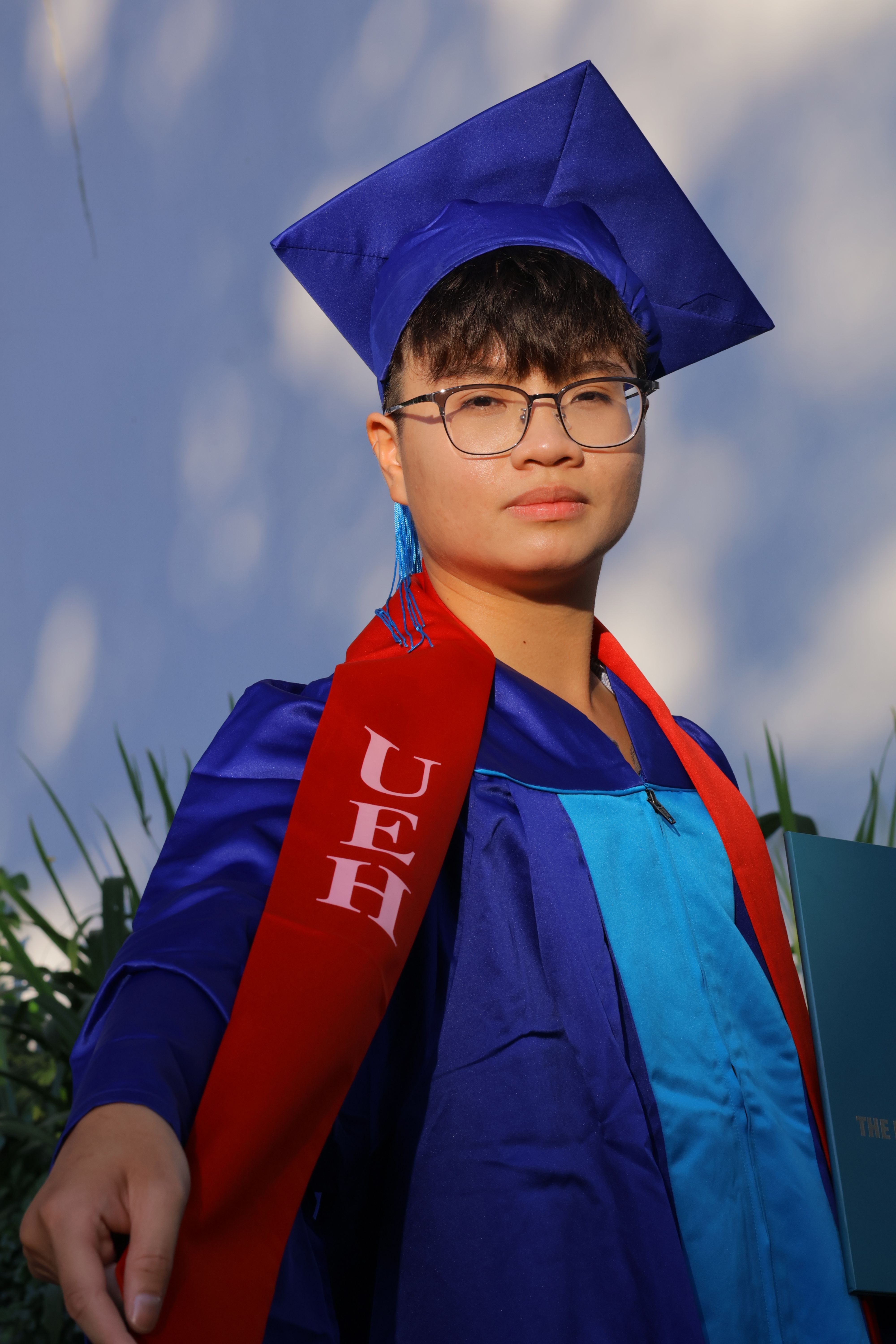 Confident young adult in graduation attire posing outdoors, embodying achievement and new beginnings.