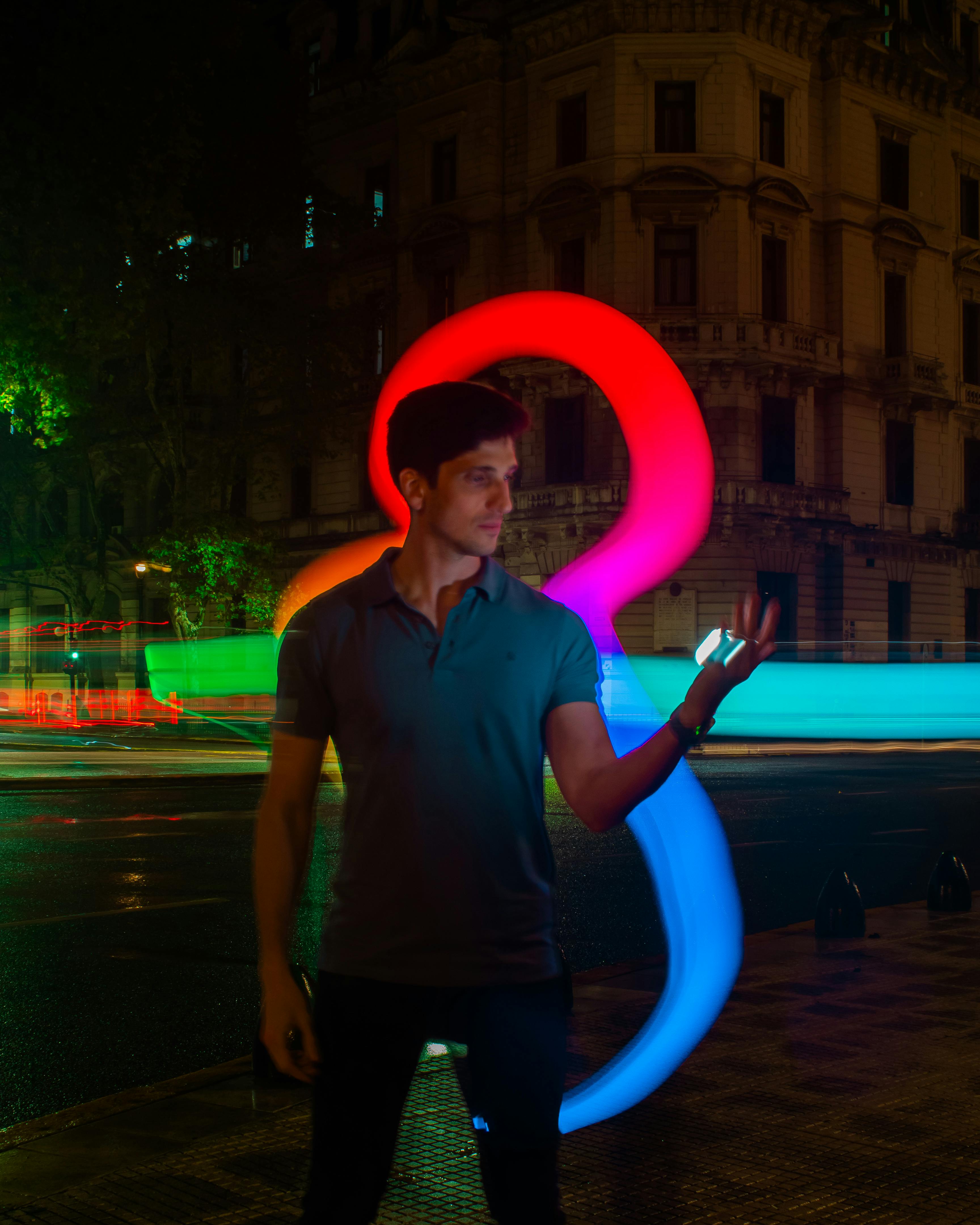 Dynamic night scene of a man with colorful light trails in Buenos Aires, Argentina.