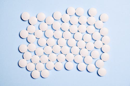White Round Tablets on White Surface