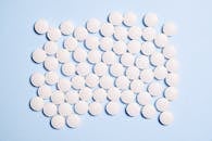 蓝色表面上的白色圆形药丸平坦，非常适合医学主题内容