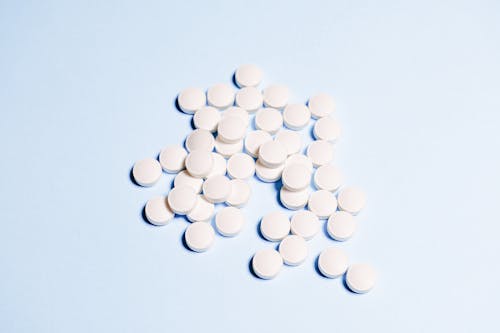 White Round Medication Pills on Sky Blue Surface