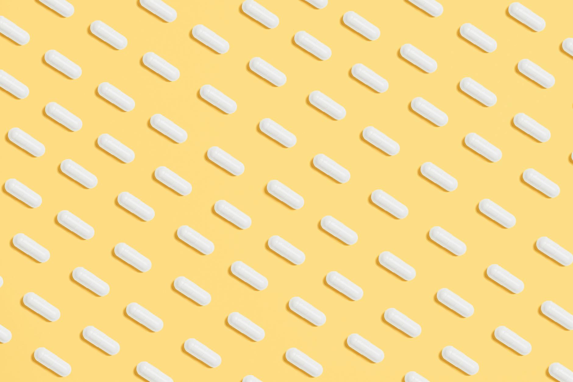 White Capsules on Yellow Background