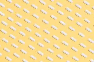 White Capsules on Yellow Background