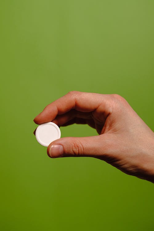 Person Holding White Round Plastic