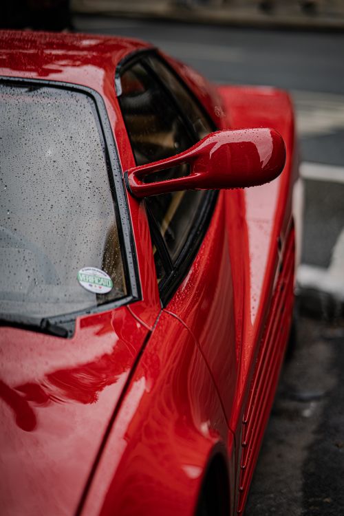 Free Close-up of a sleek red sports car with raindrops on its surface, parked in São Paulo. Stock Photo