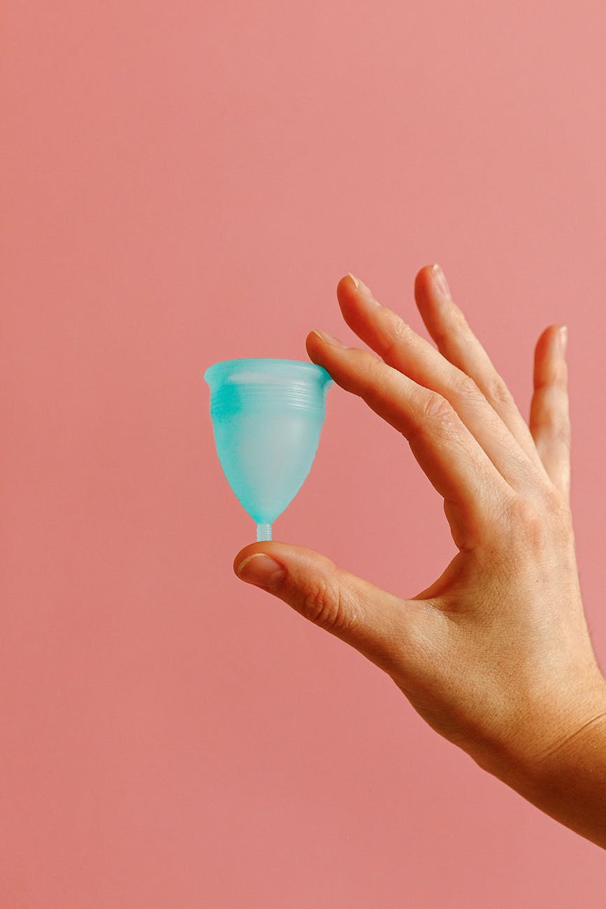 a hand holding a menstrual cup