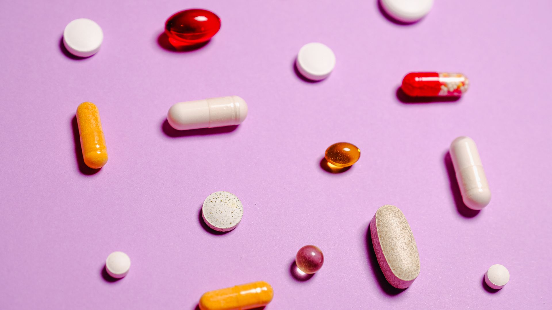 Modafinil Addiction Potential: Exploring the Risks and Benefits Various colorful pills and capsules scattered on a purple surface, representing healthcare and medication — modafinil addiction potential
