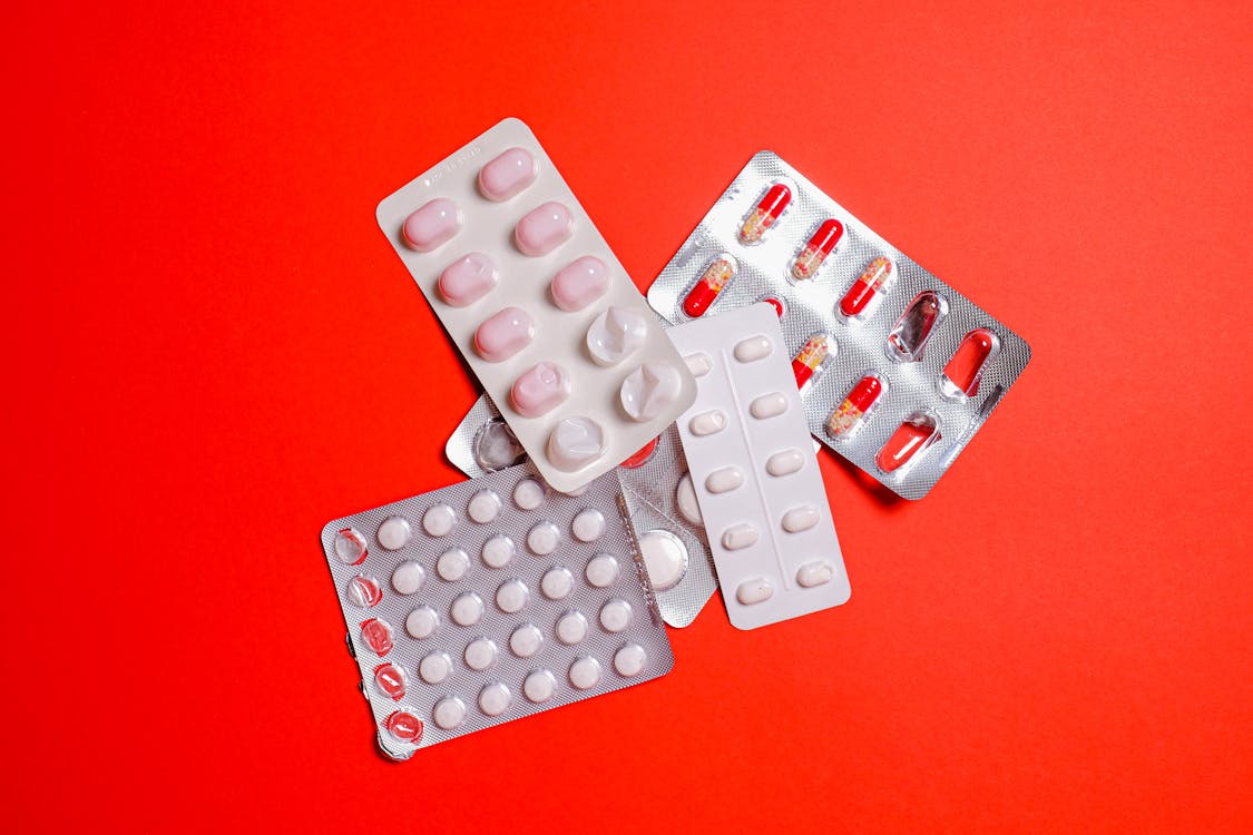 Free Medicine Blister Pack on Red Surface Stock Photo