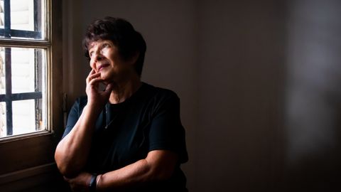 Thoughtful senior woman looking out a window, lost in reflection and quiet contemplation.