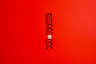 红色背景上抽象排列的药丸，非常适合表现健康和医学概念