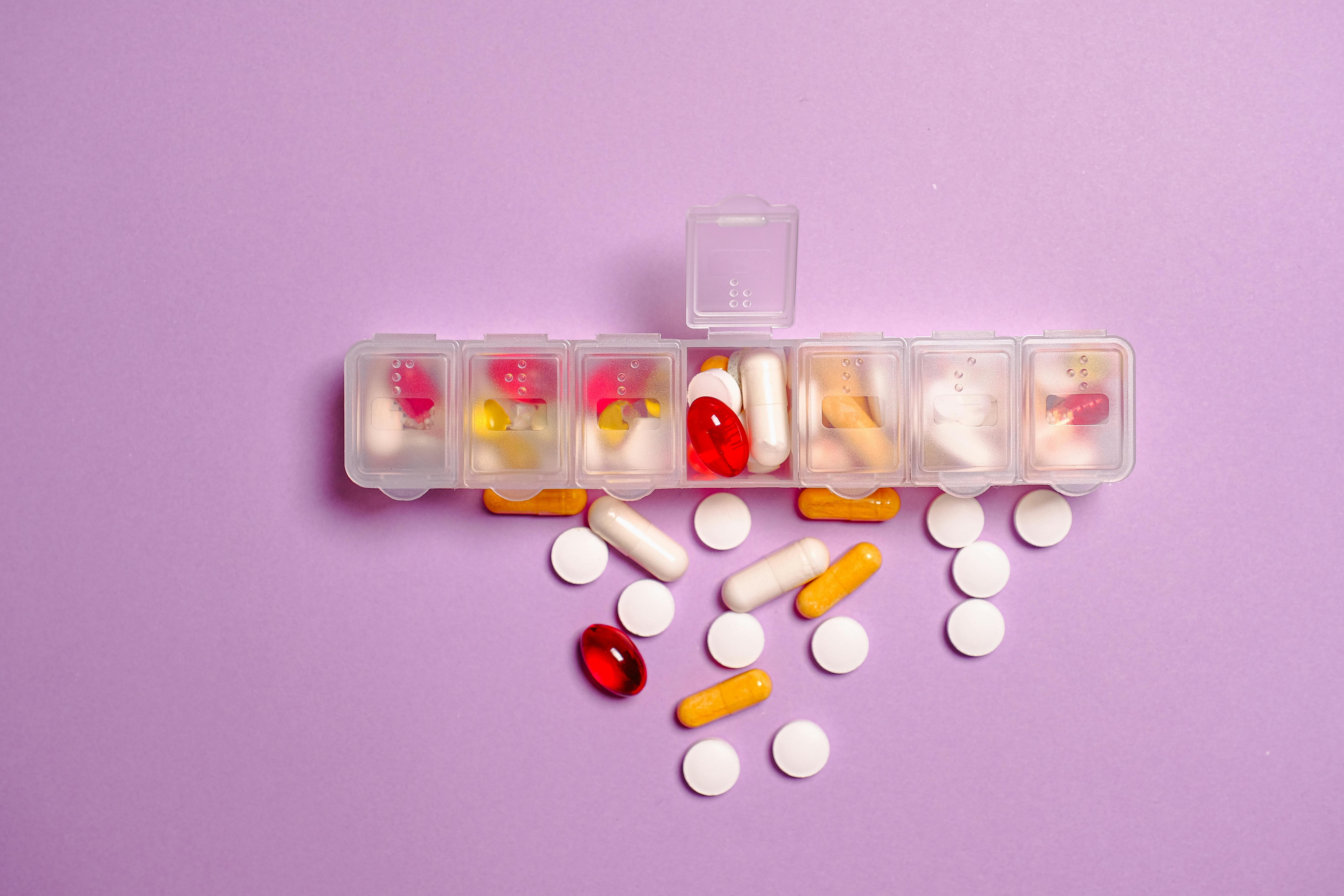 clear plastic medicine container on violet surface