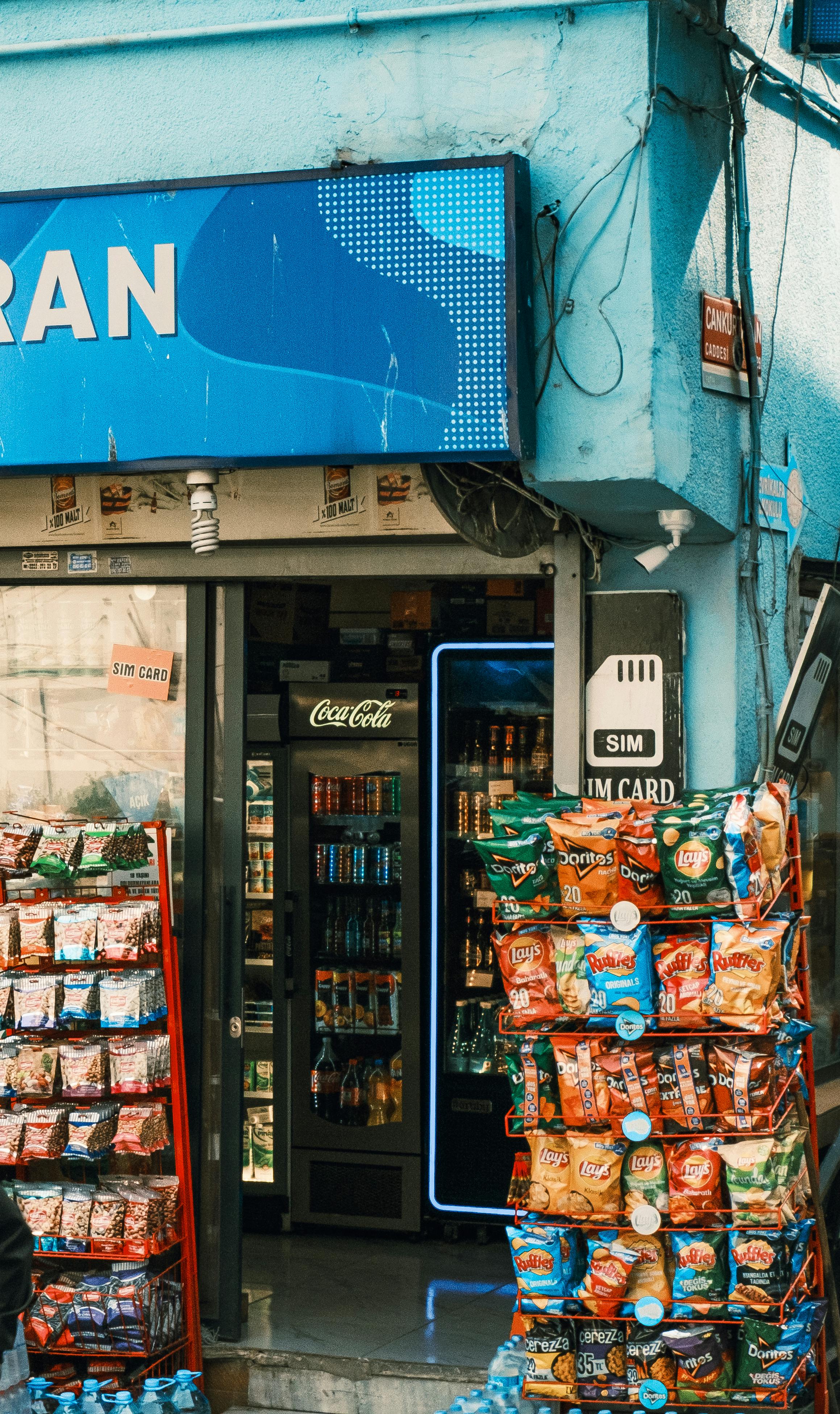 A vibrant display of snacks and SIM cards at a local convenience store entrance.