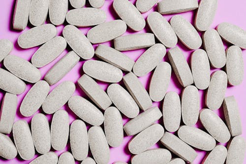 Белые таблетки лекарства, изолированные на фиолетовом фоне