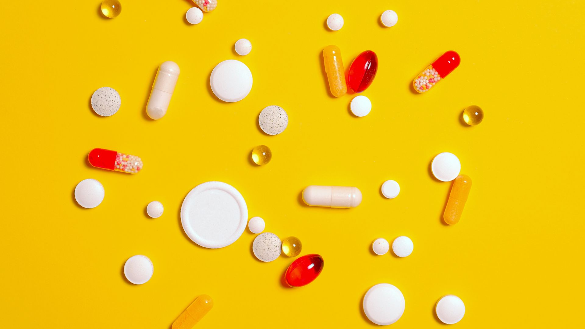 Armodafinil Vs Modafinil Which Is Better: Armodafinil vs Mod A variety of pills and capsules scattered on a vibrant yellow backdrop, emphasizing health and medicine — armodafinil vs modafinil which is better