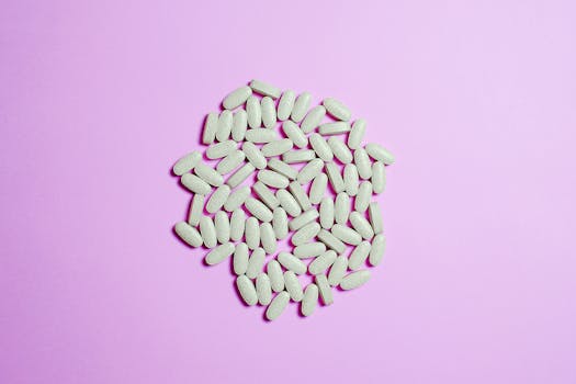 紫色表面上的白色药丸簇突出了制药主题