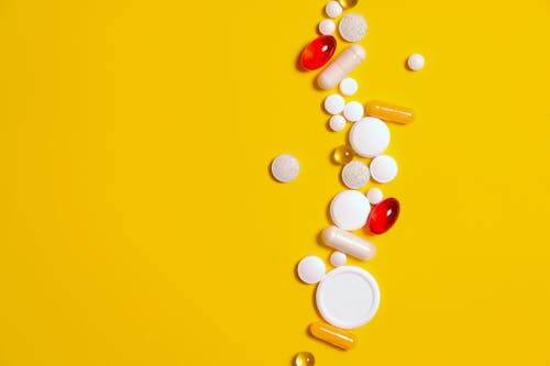 Free Medication Pills Isolated on Yellow background Stock Photo