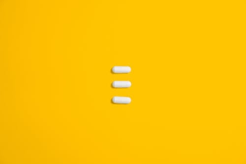 Free White Three Oval Capsule on Yellow Canvas Stock Photo