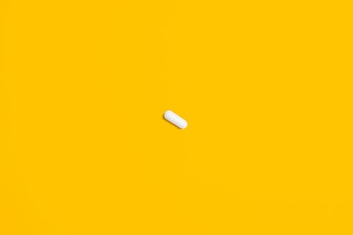 White Pill on Yellow Surface