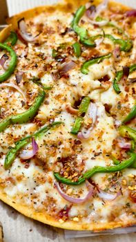 Close-up of a cheesy vegetarian pizza topped with green peppers and onions, perfect for food lovers.