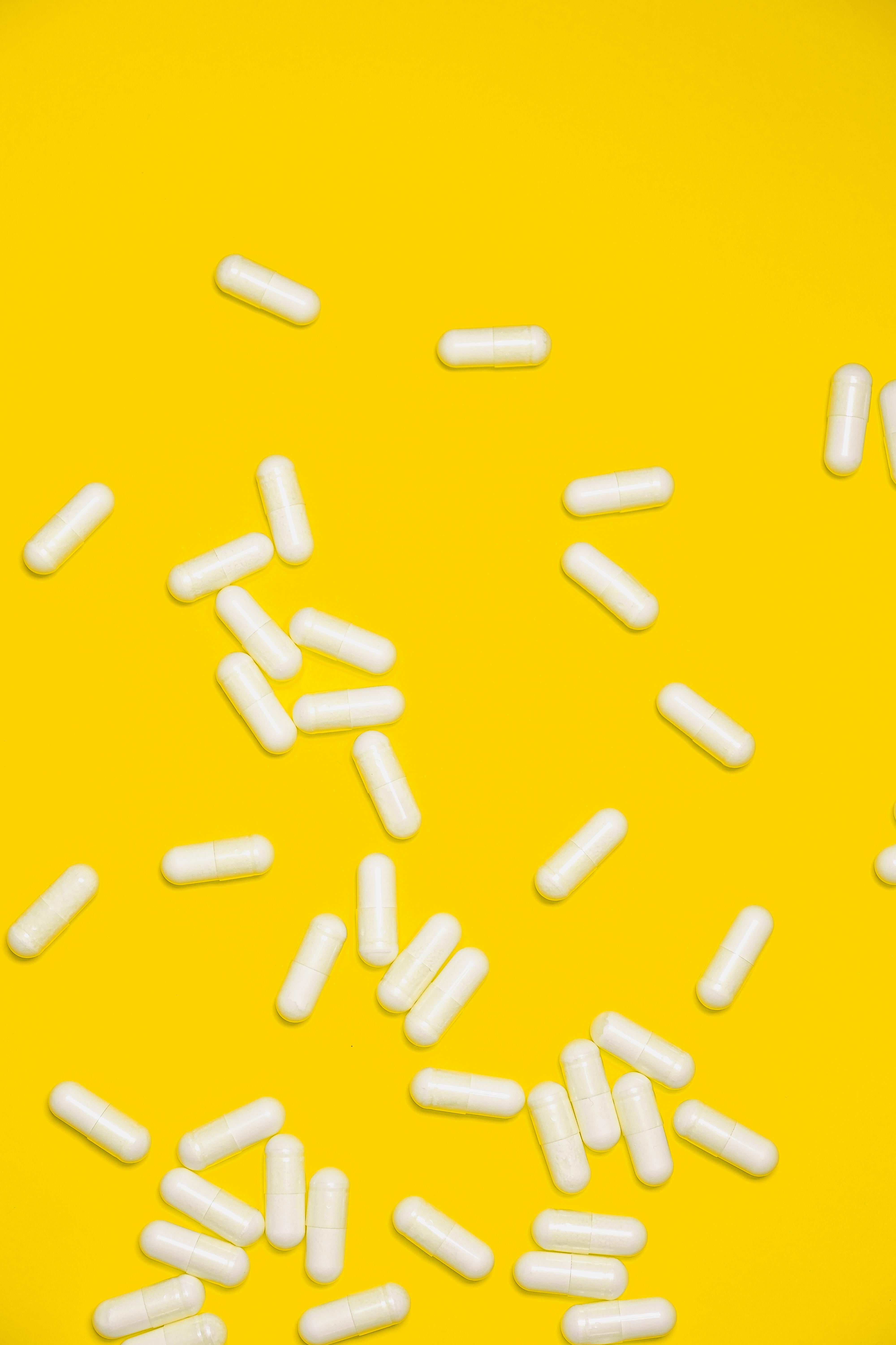 White Medication Pills Isolated on Yellow background \u00b7 Free Stock Photo
