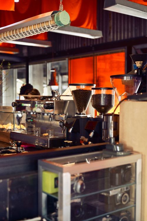 Free Warm and inviting cafe interior featuring a modern espresso machine and coffee grinders. Stock Photo