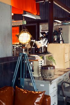 Cozy industrial office setting featuring a vintage tripod lamp and rustic decor.