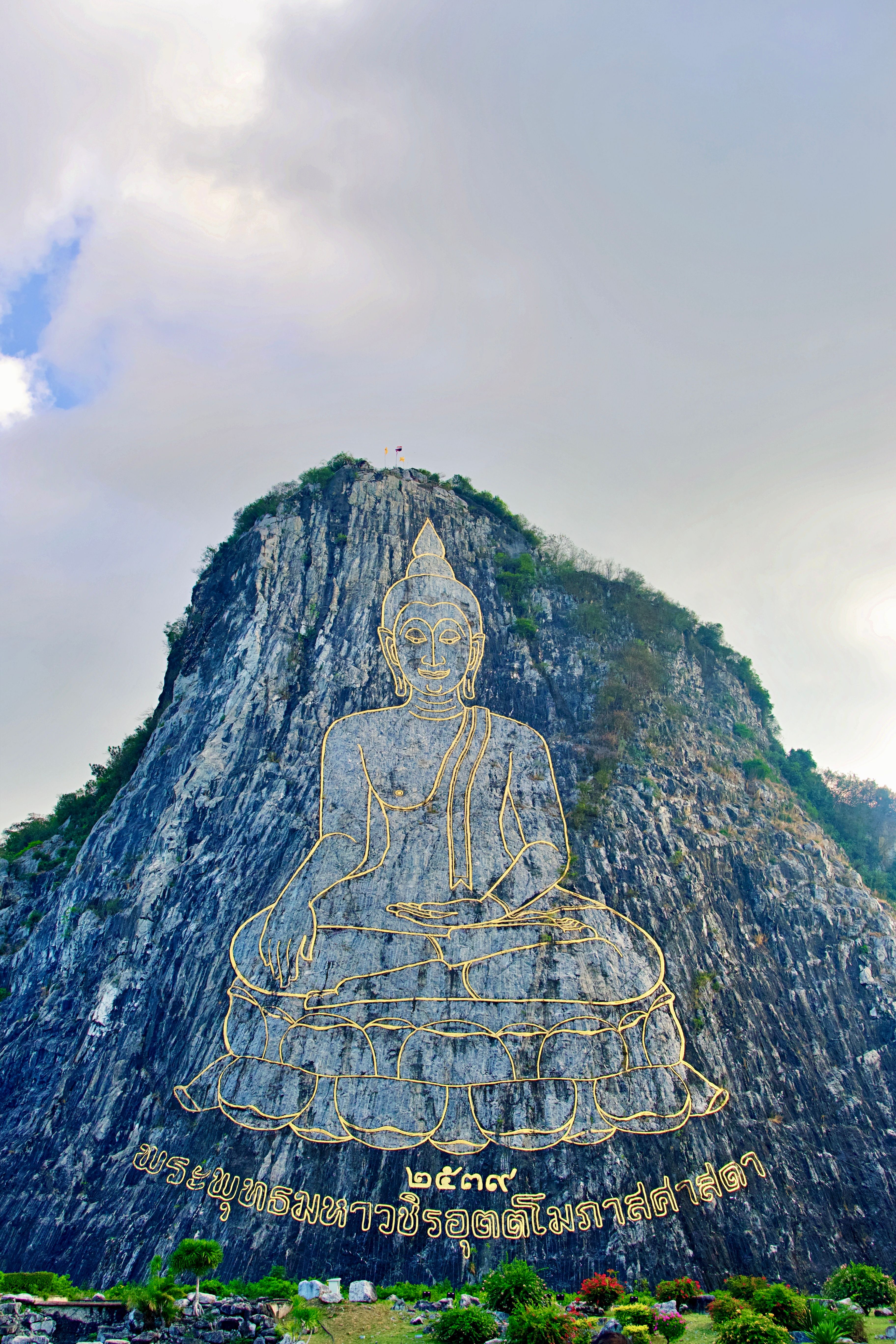 Majestic image of the Golden Buddha carving on Khao Chi Chan Mountain in Thailand.