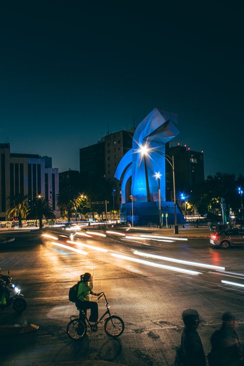 Free Dynamic long exposure of a bustling Mexico City street at night featuring the iconic Cabeza de Juárez sculpture. Stock Photo