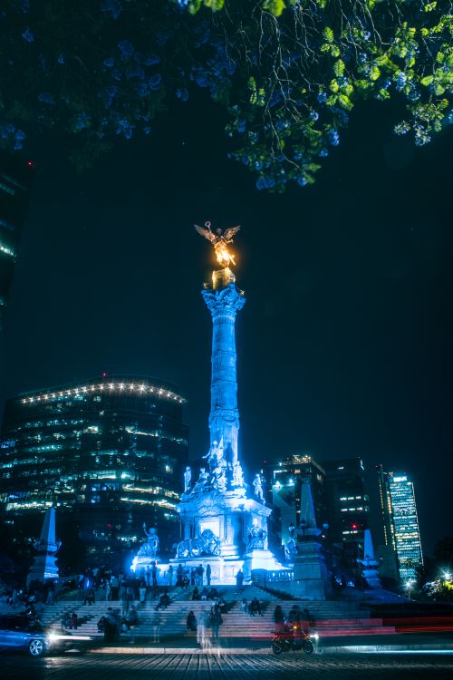 Free The Angel of Independence monument beautifully lit at night in Mexico City, showcasing vibrant city life. Stock Photo