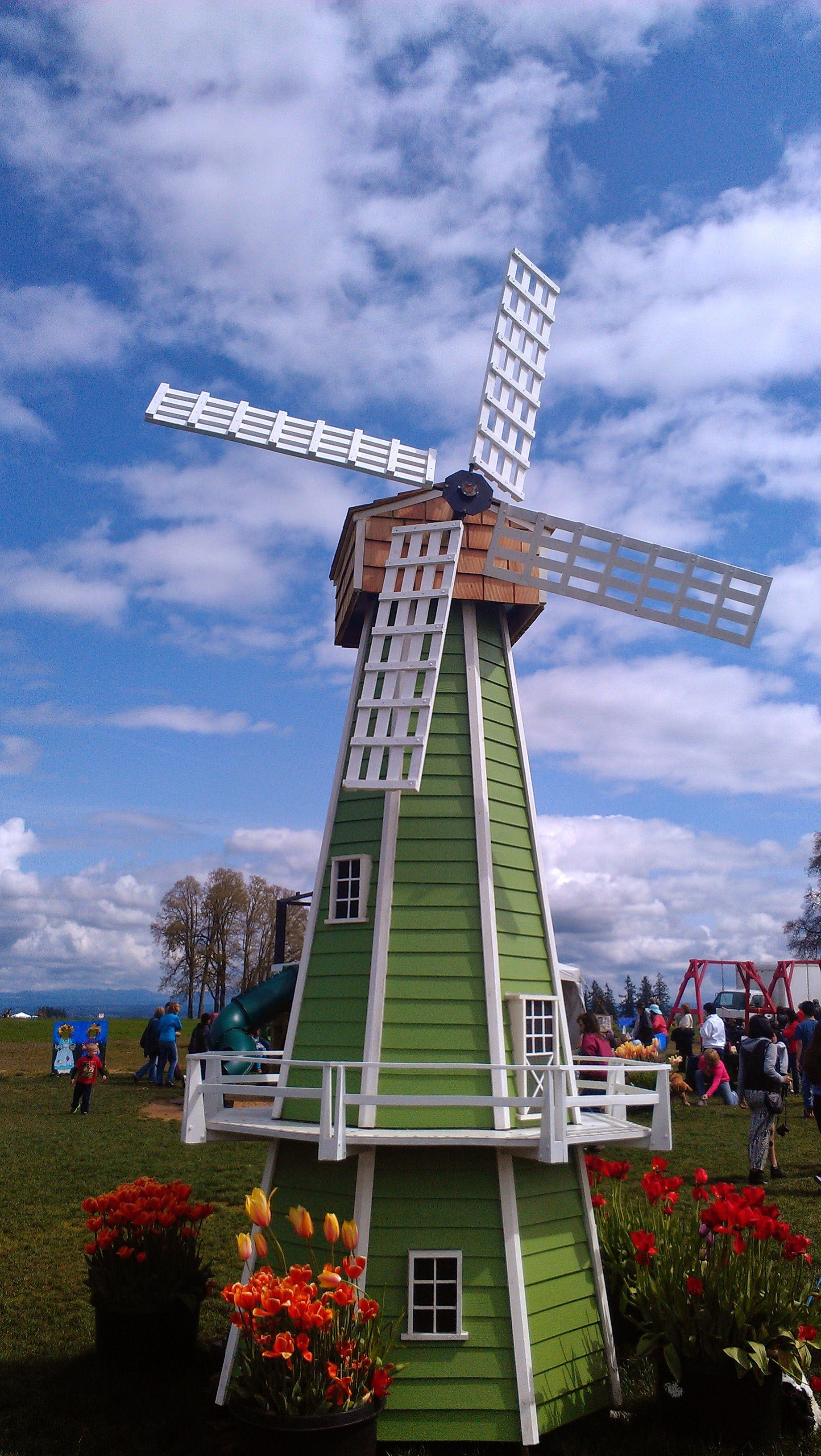 Charming Green Windmill in Spring Festival Setting · Free Stock Photo