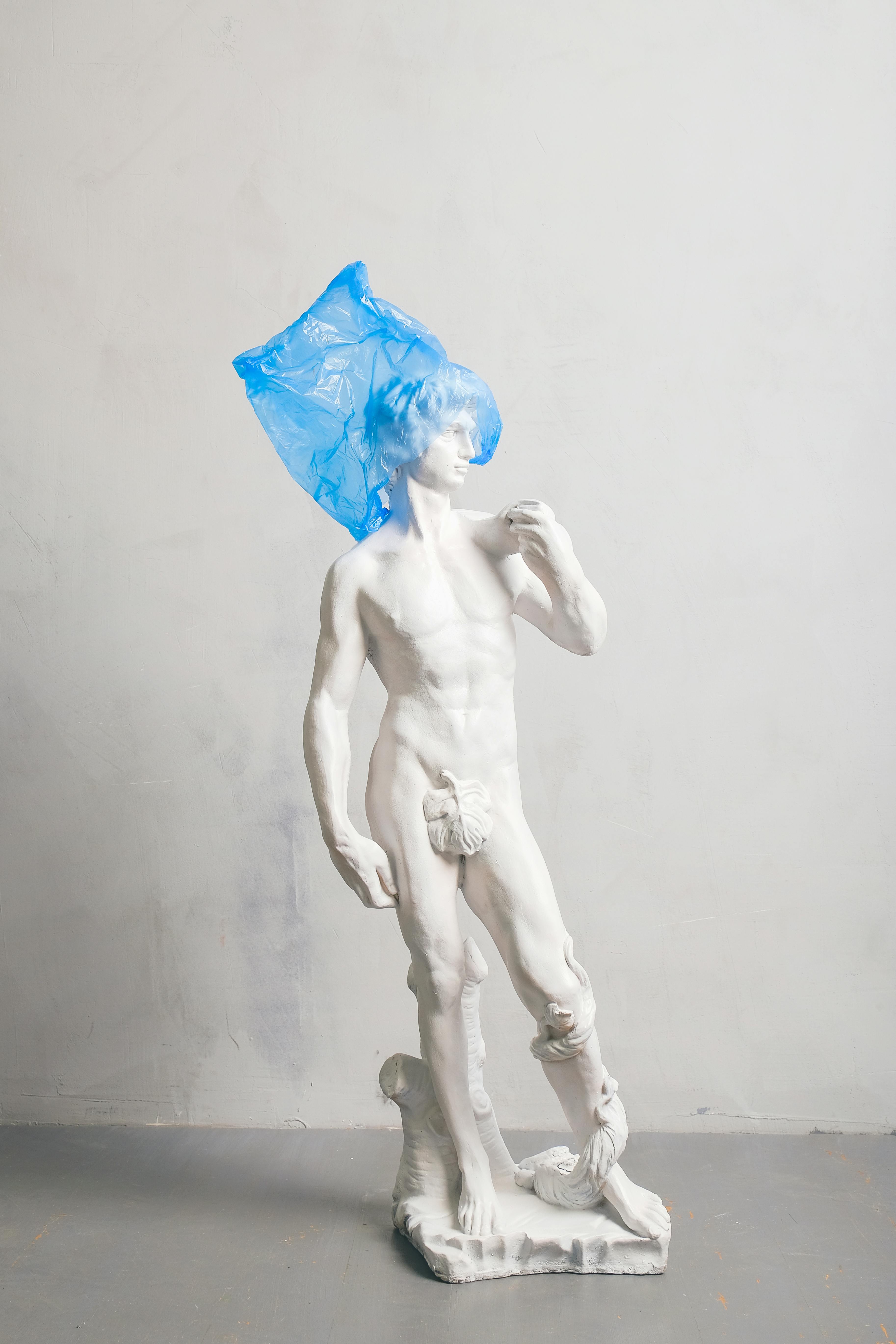 white nude sculpture covered blue plastic on head