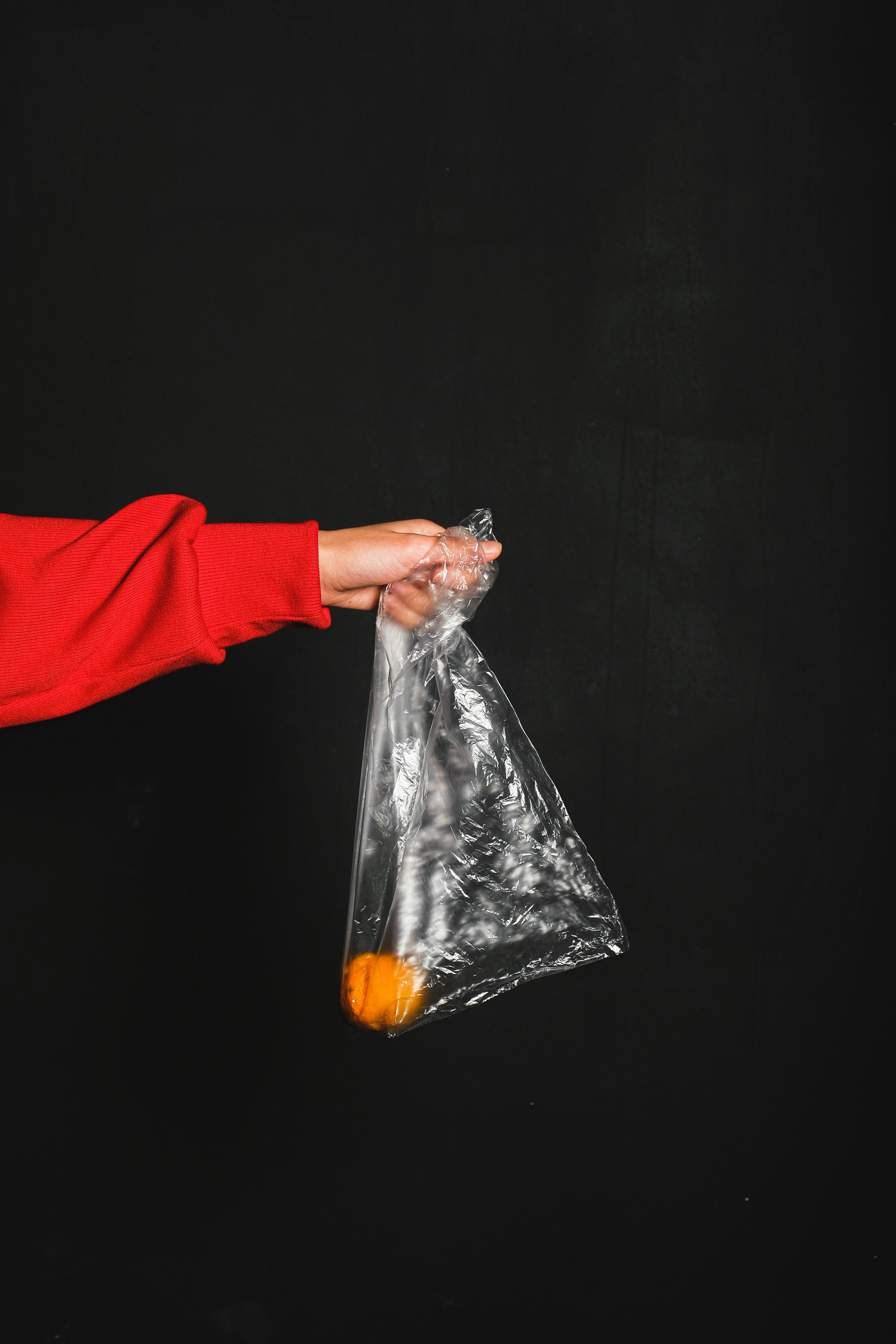 Person in Red Long Sleeve Top Holding Colorless Plastic ...