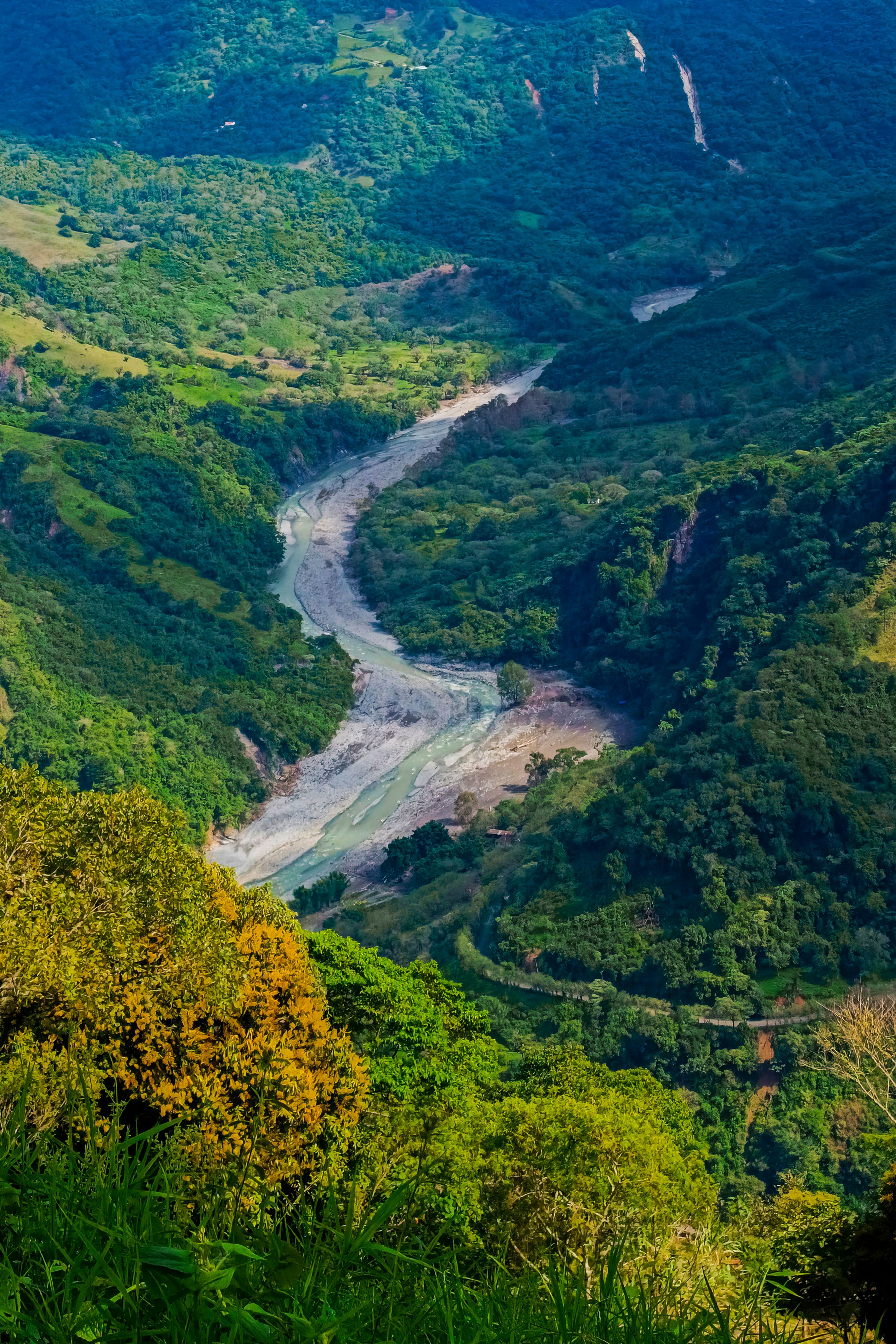 Aerial View of a River Flowing between Green Hills · Free Stock Photo