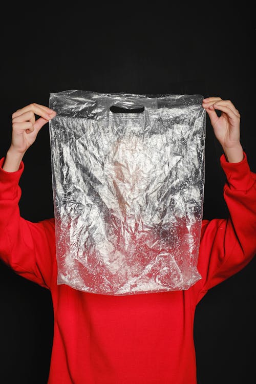 Person Wearing Red Top Holding Clear Plastic Bag