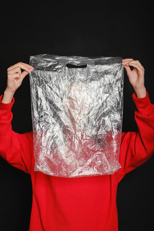 Free Person Wearing Red Top Holding Clear Plastic Bag Stock Photo
