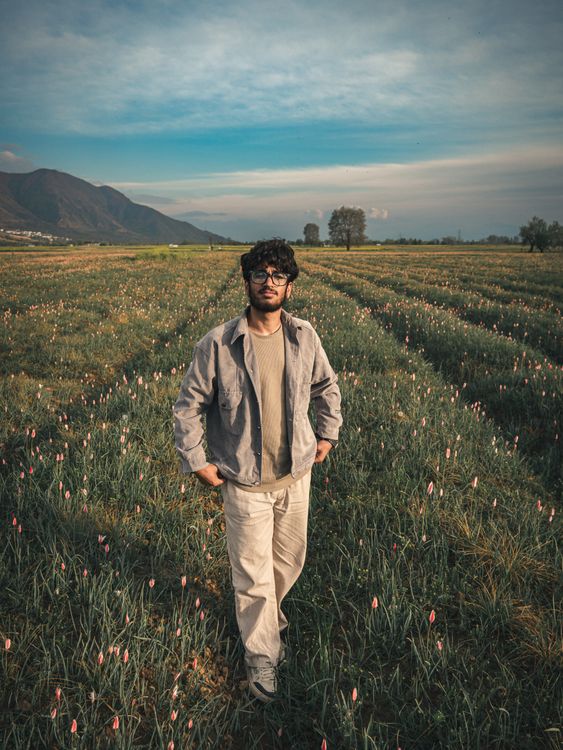 Young Man Standing in Field at Dusk · Free Stock Photo