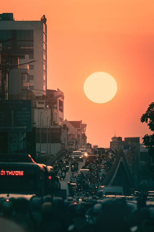 Free Bustling city street packed with vehicles during sunset, vibrant sky enhancing urban chaos. Stock Photo