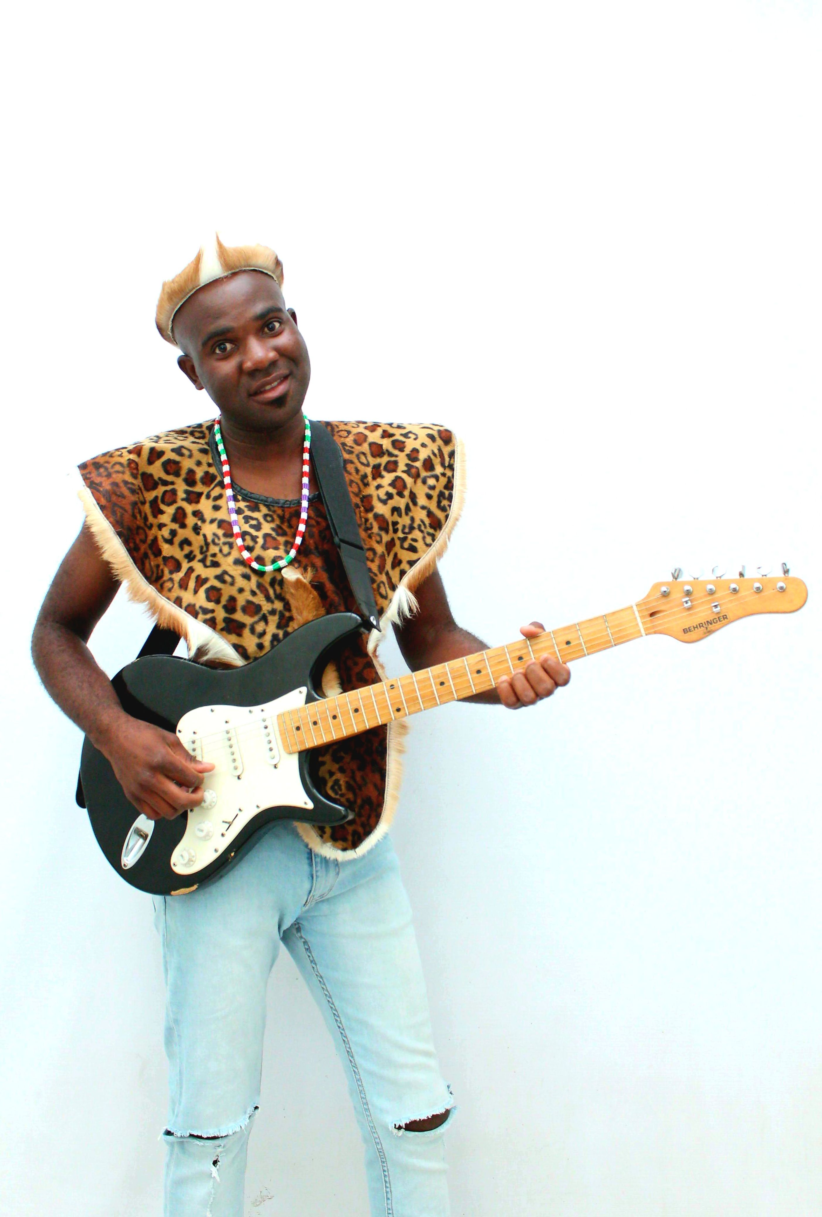 Man in cultural attire playing an electric guitar against a white background.