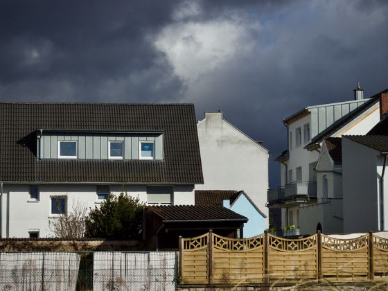 Suburban houses under a heavy, dark cloud front