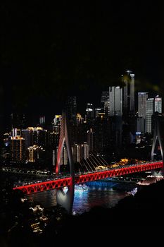 Stunning nightscape of Chongqing city featuring a brightly lit bridge and skyline.
