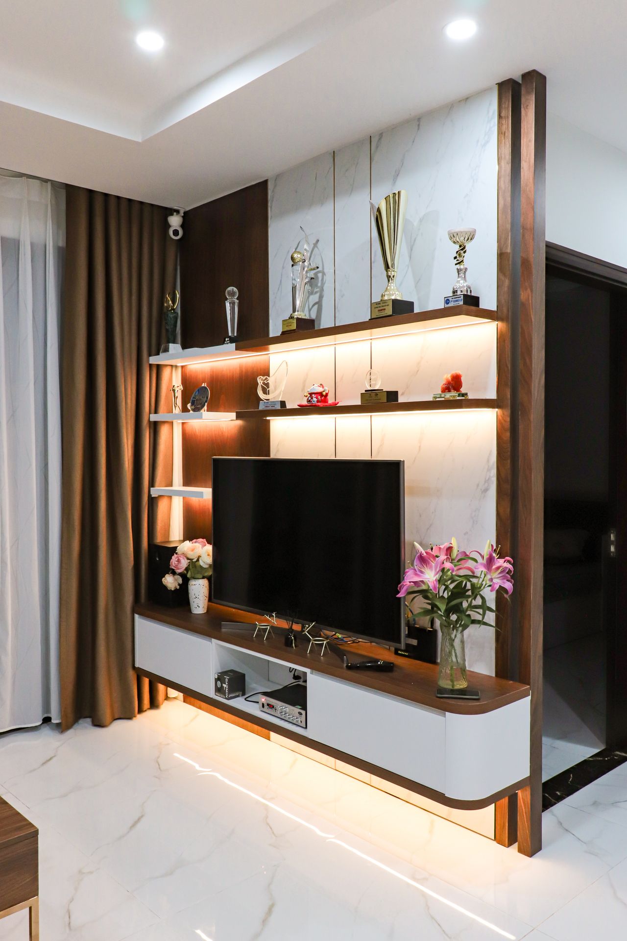 Modern TV console wall unit with open shelves and warm backlighting