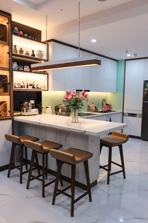 Free Stylish kitchen with a marble island, bar stools, and contemporary decor. Stock Photo