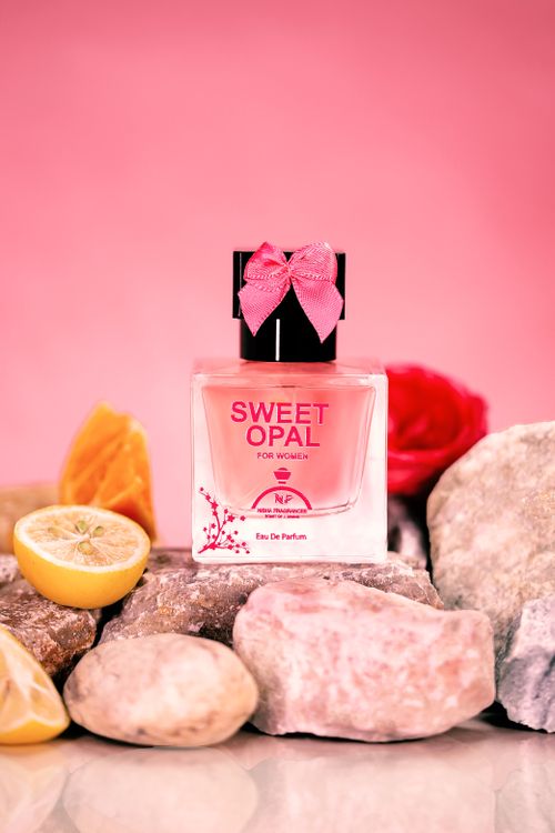 Free A stylish Sweet Opal perfume bottle with floral accents, set against a pink background. Stock Photo