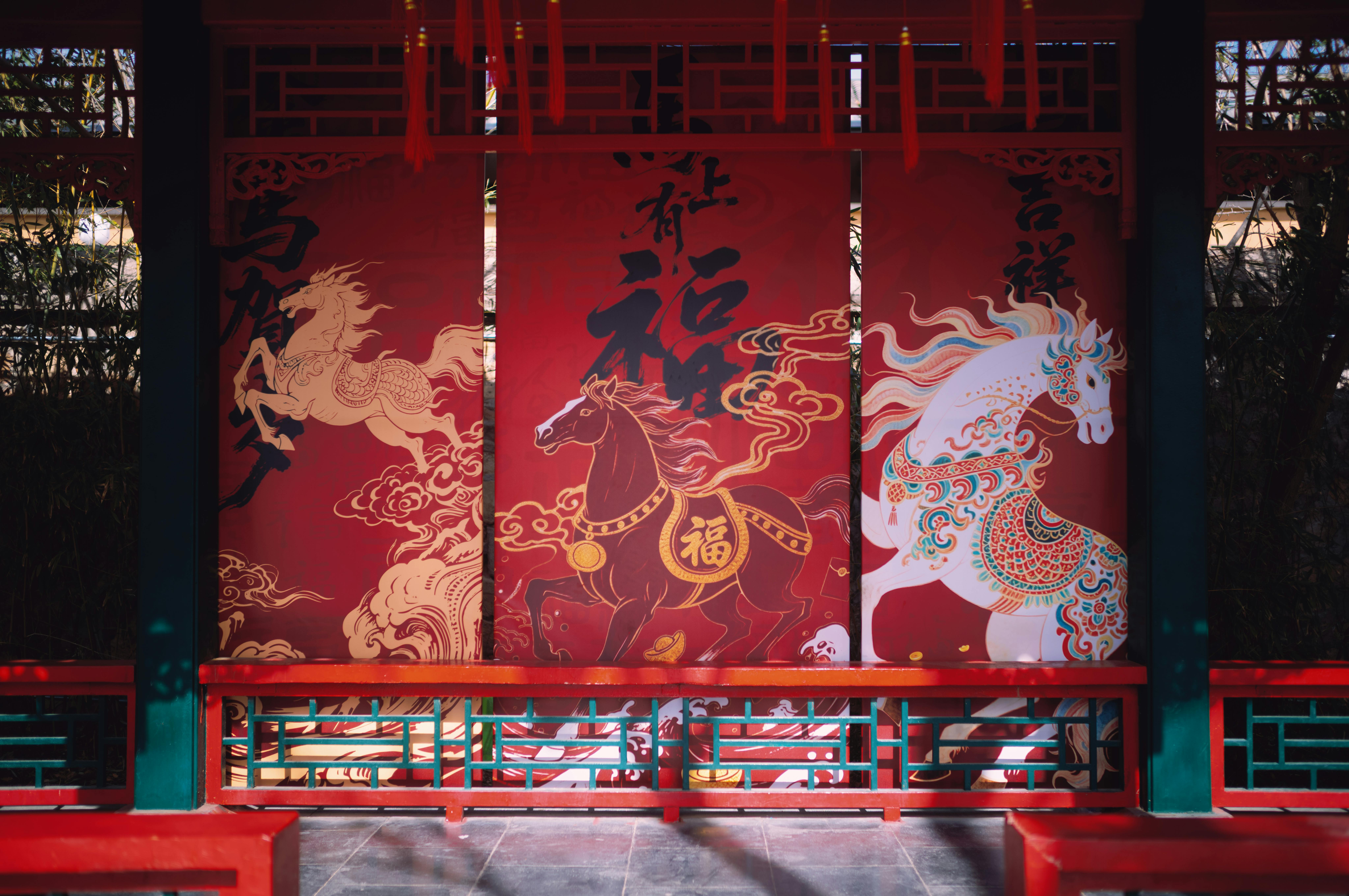 Vibrant Chinese horse artwork displayed in a traditional Beijing pavilion, highlighting cultural artistry.