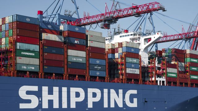 Container vessel alongside quay cranes in a busy port